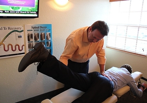 Chiropracter lifting patient's leg